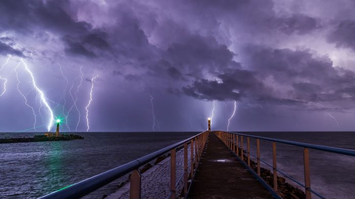 lightning bolts illuminating dark storm clouds at night